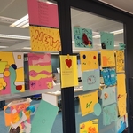 Colour paper with sketches pinned to a meeting room glazed wall