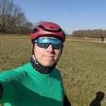 Calum in a green cycling lycra top and red cycling helmet a clear Spring evening in Richmond Park