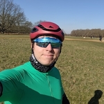 Calum in a green cycling lycra top and red cycling helmet a clear Spring evening in Richmond Park