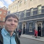 Calum smiling close-up with backdrop of 10 Downing Street