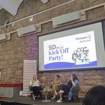 Panel of 3 female speakers below a projector screen at SDinGov pre-event session