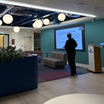 Presenter beside a sofa and Skyscanner lecturn at the CAN meetup