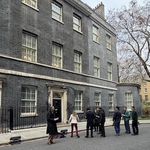 Outside No.10 Downing Street a cluster of people wait to post for photographs
