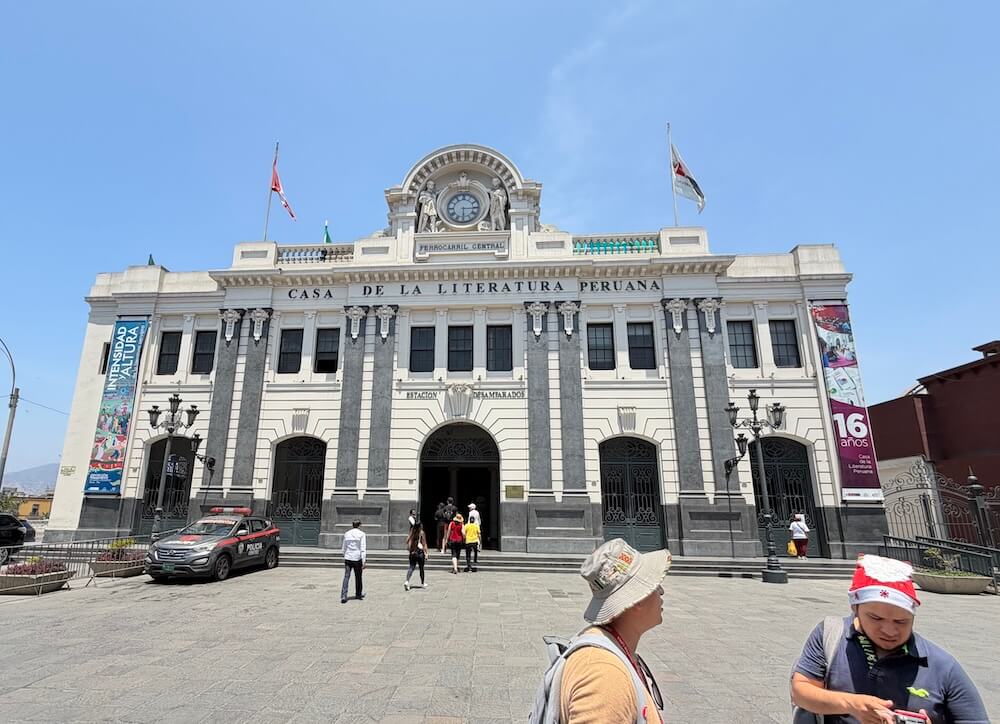 Historic train station in Lima, now a literary centre with banners and neoclassical facade.