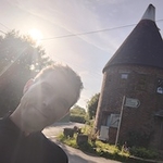 Calum in sunlit profile beside Oast House