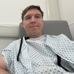 Calum sitting in a hospital gown