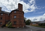 A pretty corner house made of red bricks in a country lane junction