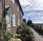 Pretty terraced cottages beside a pathway and fence overlooking a high viewpoint