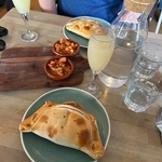 Empanadas and Pisco sours on a table with salsa