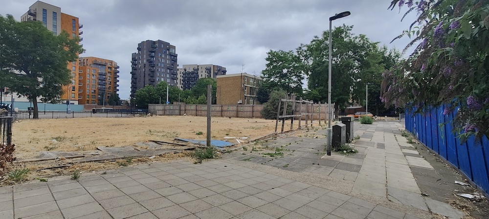 Colourful assortment of high-rise flats in East London and derelict ground in foreground