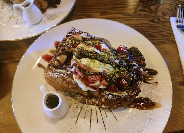 French Toast on decorated plate and caramel sauce in a serving cup