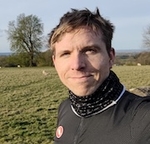 Calum in cycle wear beside a field
