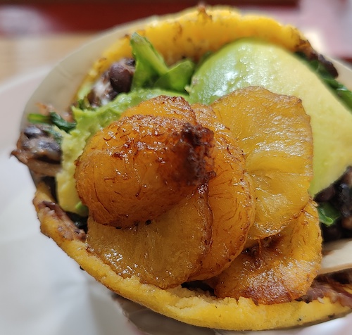 close up of arepa with beans and avocado