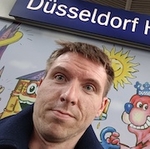 Profile shot in front of Düsseldorf Hbf sign