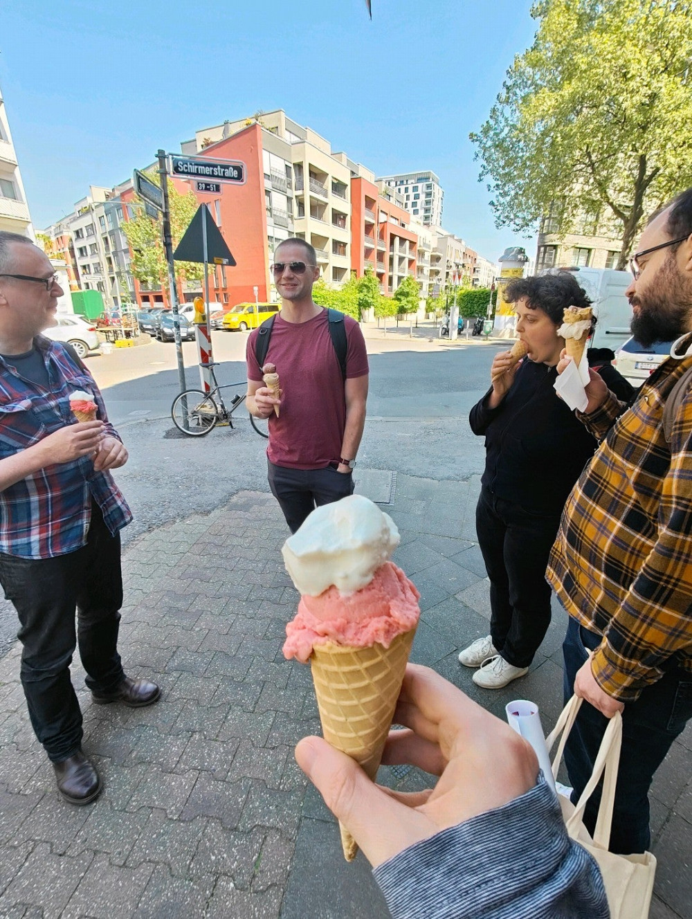 Holding a cone of ice cream with vanilla and rhubarb. Backdrop of other btconf attendees