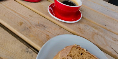 Coffee and walnut cake with coffee. Red Canyon helmet on a table