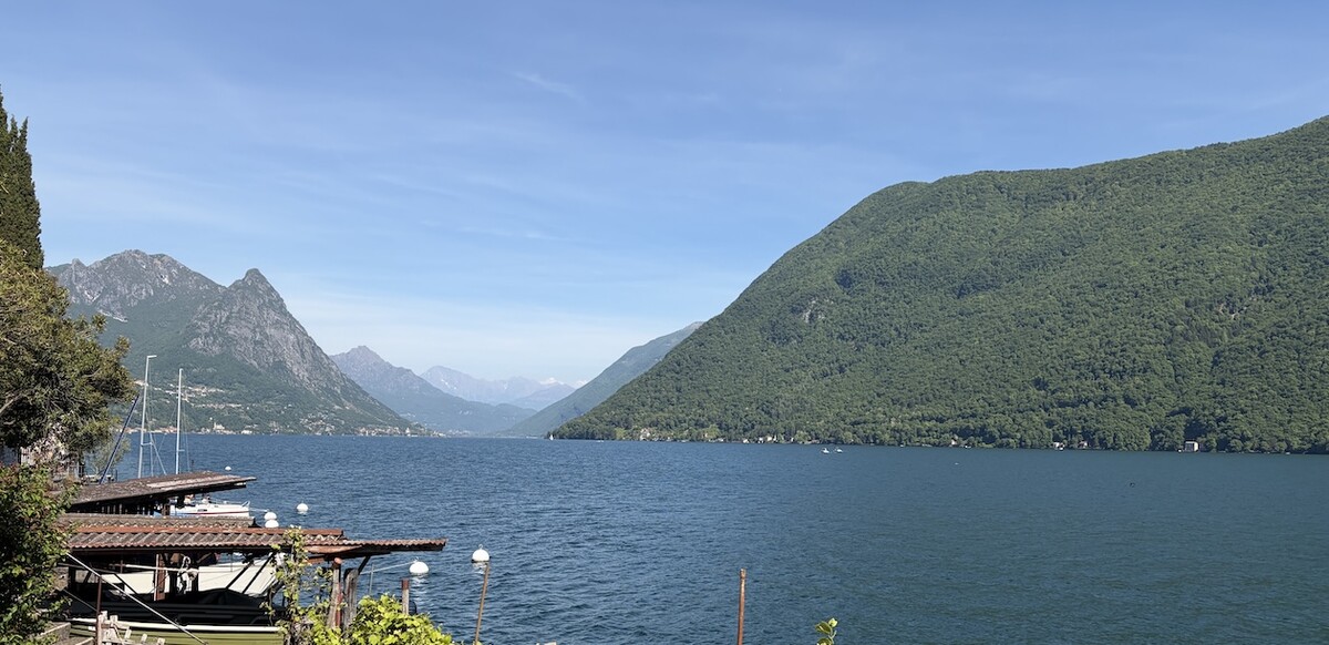 Landscape view of Lugano lakeside shore and mountains in foreground