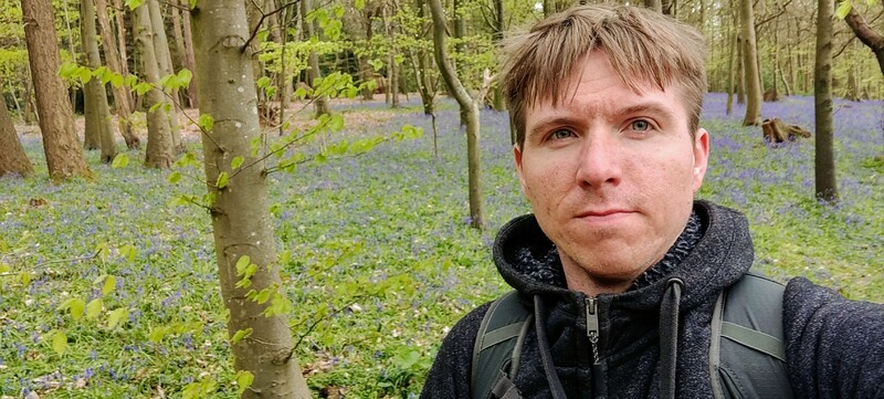 Calum with backdrop of bluebell covered forest