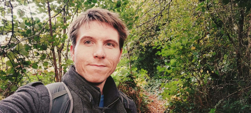 Calum with backdrop of tree-line footpath