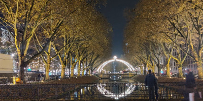 Night shot of Düsseldorf river and Christmas arc of lights with star