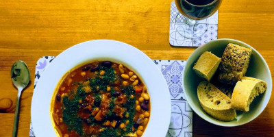 Bean stew in a white plate with bread and red