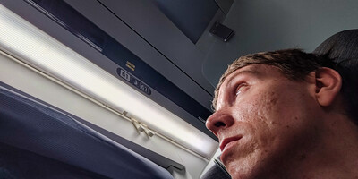 Calum looking above his train seat at number 61