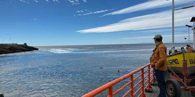 Calum beside the Pacific ocean with clear blue sky