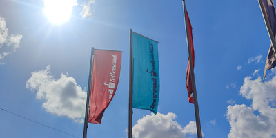 Beyond Tellerrand flags to the backdrop of a clear blue sky and flaring sunshine