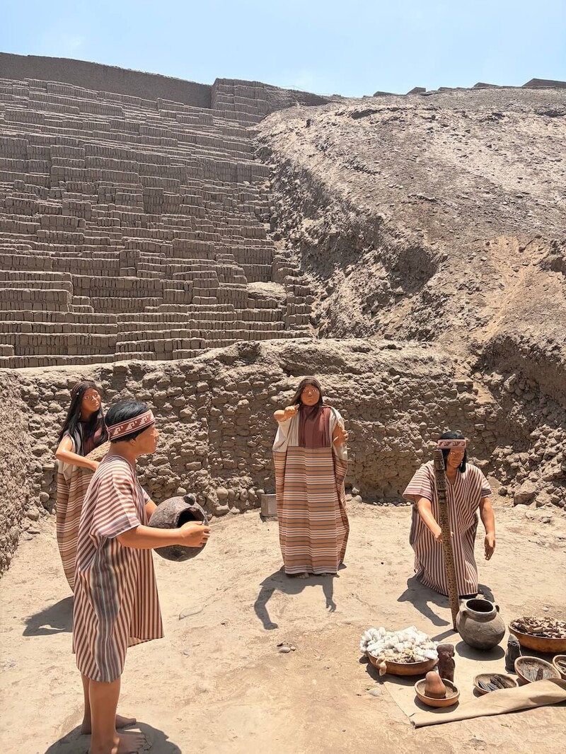 Huaca Pucllana pyramid with a group of lifesize figures from the period re-enacting making food