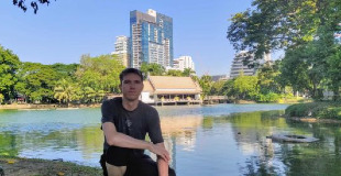 Calum perching by a lake in Lumphini Park
