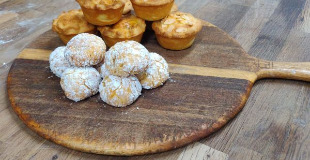 Freshly baked mince pies and amaretti biscuits on a round wooden board